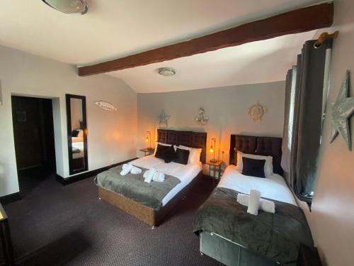 a bedroom with two beds and a large mirror at Bay view rooms at Mentone Hotel in Weston-super-Mare