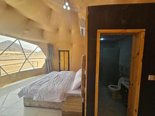 a bedroom with a bed in a room with a window at Kylie magic camp in Wadi Rum