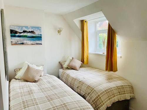 two beds in a bedroom with a window at Bewdley Central - Sandy Bank Cottage in Bewdley