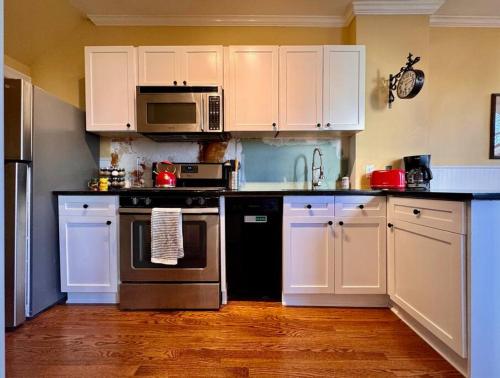 cocina con armarios blancos y fogones en Historic Home in Washington DC w Hot Tub & Parking, en Washington