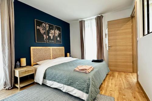 a bedroom with a bed with a blue wall at Airbnb à Paris-Bois de Vincennes in Saint-Maurice