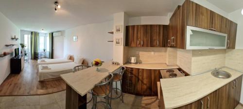 een keuken met houten kasten en een woonkamer bij Дом Крумови in Boergas