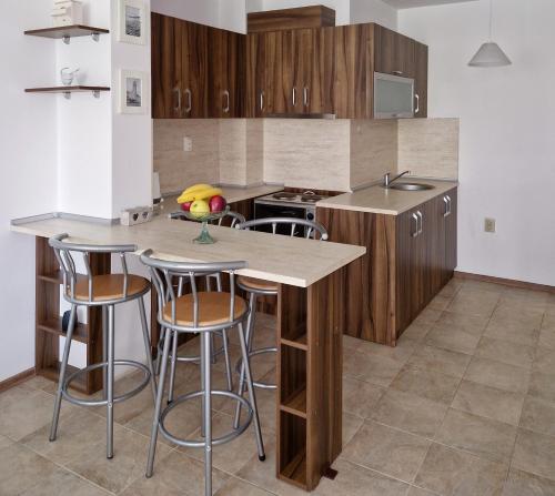 een keuken met houten kasten en barkrukken bij Дом Крумови in Boergas