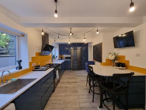 a kitchen with a sink and a table with chairs at Marina View in Castletown