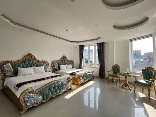 a bedroom with two beds and a table and chairs at Tam Đảo Gold Hotel in Tam Ðảo