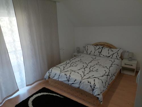 1 dormitorio con 1 cama con edredón blanco y negro en Casa Mario 2 en Oradea