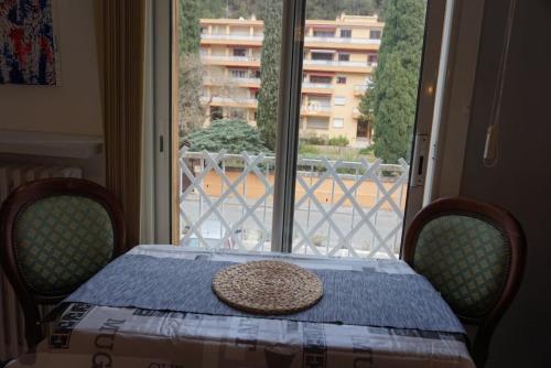 une table avec un chapeau en haut et une fenêtre dans l'établissement Amelie les Bains Coquet F1, à Amélie-les-Bains-Palalda