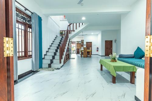 a living room with a blue couch and stairs at Villa Talpe in Talpe