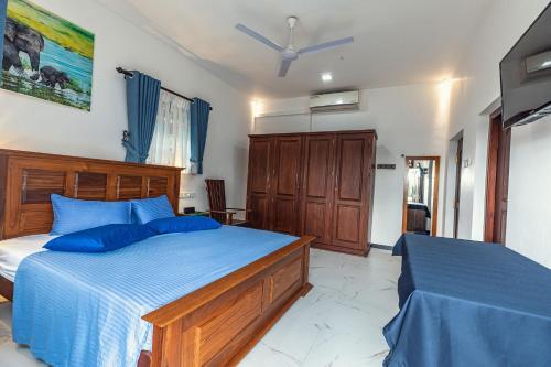 a bedroom with two beds with blue pillows at Villa Talpe in Talpe