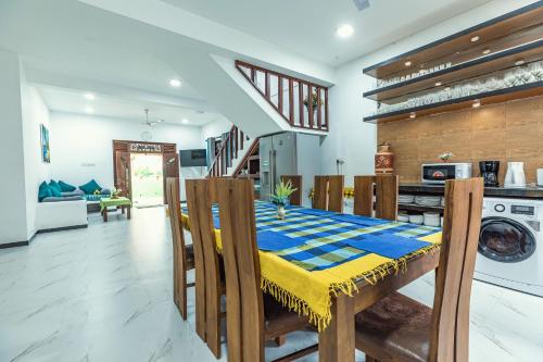a kitchen and dining room with a table and chairs at Villa Talpe in Talpe