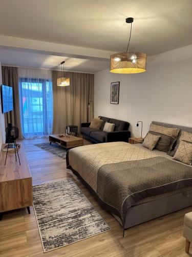 a bedroom with a bed and a living room at La Victoria in Janske Lazne