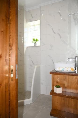 a bathroom with a tub and a sink and a shower at Platanos Apartments in Kalymnos