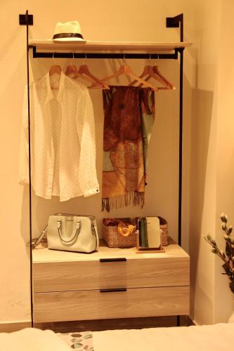 a closet with a dresser with clothes and a purse at Apidalos Apartments in Corfu