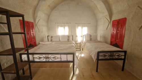 two beds in a room with red doors at KING SOLOMON PALACE in Avanos