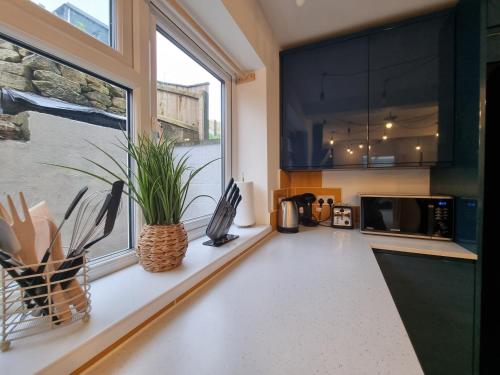 a kitchen with a counter with a microwave and a window at Marina View in Castletown