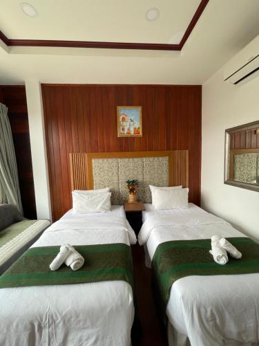 a bedroom with two beds with towels on them at โมเมนต์ แอ๊ท ริมโขง in Chiang Khan