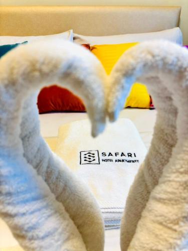 a bed with towels in the shape of a heart at Safari Hotel Apartments in Ajman 