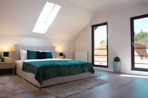 a bedroom with a bed and two windows at Zenith - Alpine Retreat in Zărneşti