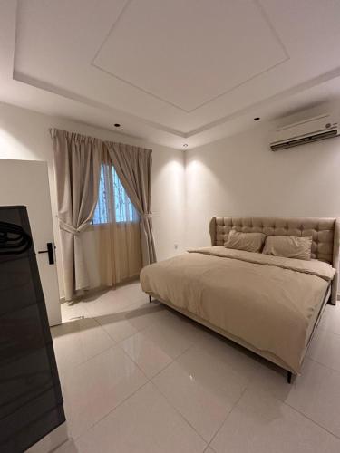 een slaapkamer met een groot bed en een raam bij شقة حي العقيق غمام in Riyad