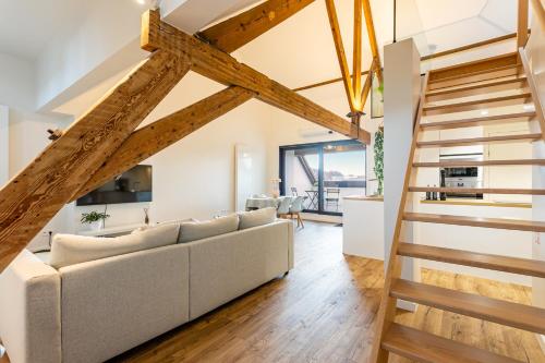 Loft Gent في خنت: غرفة معيشة مع أريكة بيضاء وعوارض خشبية
