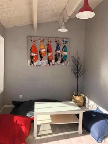 a room with a table and a painting on the wall at Charmante maison avec jacuzzi. in La Flotte