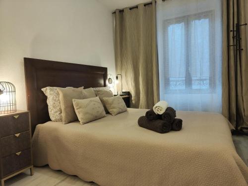 a bedroom with a large bed with towels on it at T2 plein centre-ville 40m2 in Albertville
