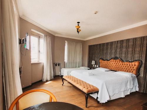 Un dormitorio con 2 camas y un banco. en Seringal Hotel en Manaos