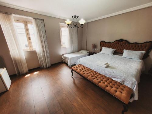a bedroom with a large bed with a bench in it at Seringal Hotel in Manaus