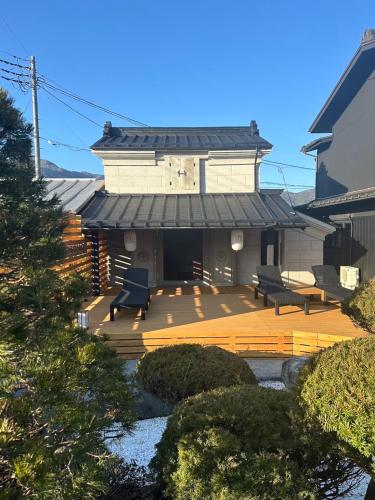 a house with a wooden deck with benches on it at KURA YARD in Fujikawaguchiko