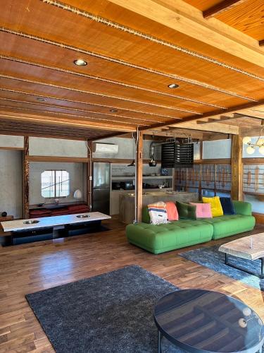 a living room with a green couch and a pool table at KURA YARD in Fujikawaguchiko