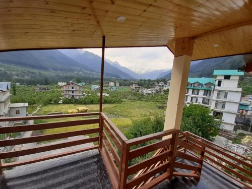 a balcony with a view of the mountains at Timber Hill Hotel in Manāli