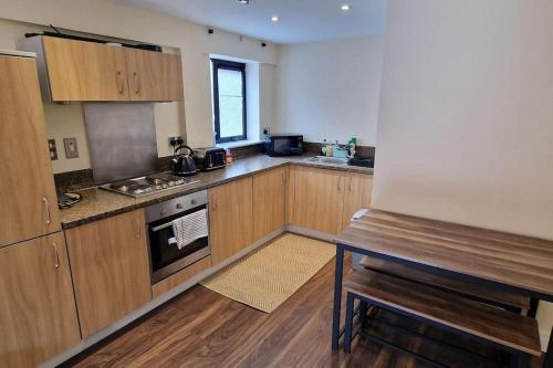 a kitchen with wooden cabinets and a stove top oven at Two Bedroom Flat B1 Birmingham ( Parking ) in Birmingham
