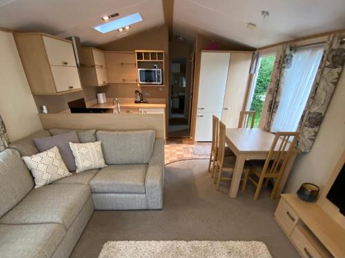 un soggiorno e una cucina con un divano e un tavolo di Caravan, Whitstable a Seasalter