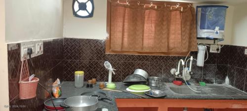 een keuken met een wastafel en een aanrecht met borden bij 1 BHK VILLA. PRIVATE VILLA. NEAR ROCK BEACH. in Pondicherry