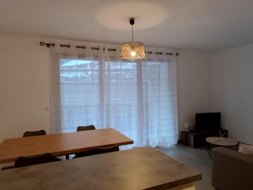 a dining room with a table and a window at Appartement au coeur de la station in Les Déserts