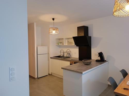 a kitchen with a counter top and a refrigerator at Appartement au coeur de la station in Les Déserts