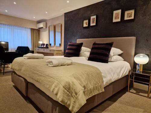 a bedroom with a large bed with two pillows at Hotel Lugano in Knokke-Heist