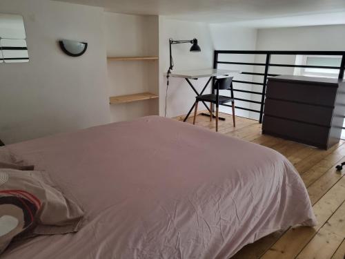 une chambre avec un lit, un bureau et une table dans l'établissement Cité du Desgn avec mezzanine et cour, à Saint-Étienne