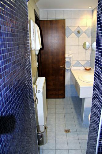 a bathroom with a sink and a toilet at Hotel Taxiarches in Aristi
