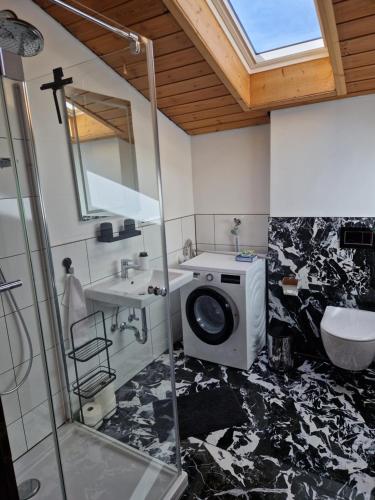 y baño con lavabo y lavadora. en Chalet Chiemgau 90 qm 3 Zimmer Balkon en Übersee