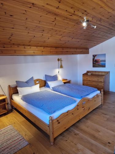 a bedroom with two beds and a wooden ceiling at Chalet Chiemgau 90 qm 3 Zimmer Balkon in Übersee
