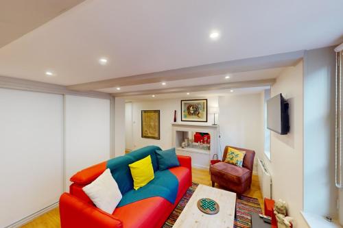 uma sala de estar com um sofá vermelho e uma cadeira em Le Repère de Popeye - nice apartment with 1 bedroom - Honfleur Center - 4p em Honfleur