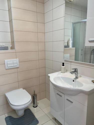 a white bathroom with a toilet and a sink at Mostar in Mostar