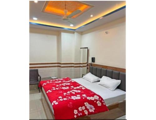 a bedroom with a bed with a red blanket at Hotel Shree Galaxy, Kanpur in Kānpur