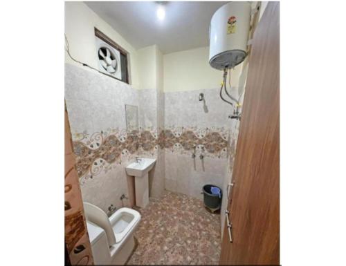 a small bathroom with a toilet and a sink at Hotel Shree Galaxy, Kanpur in Kānpur