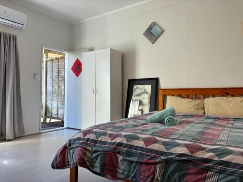 a bedroom with a bed and a sliding glass door at epsom tidy white house in Auckland