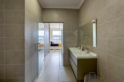 a bathroom with a sink and a mirror at StayEasy Lux Apartment in Edenvale