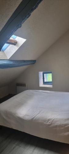 a bed in a white room with a window at Maison de montagne en pleine nature face au Mont Valier in Ercé