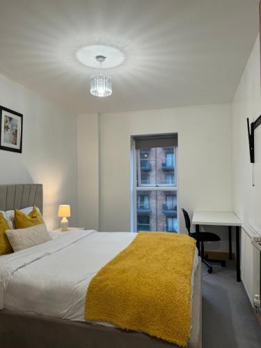 una camera con un letto con una coperta gialla di Luxury Lakeview Apartment a Dartford