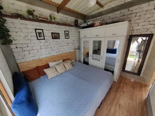1 dormitorio con 1 cama grande en una pared de ladrillo en Casa de campo Sol de la Dunas Ica en Ica